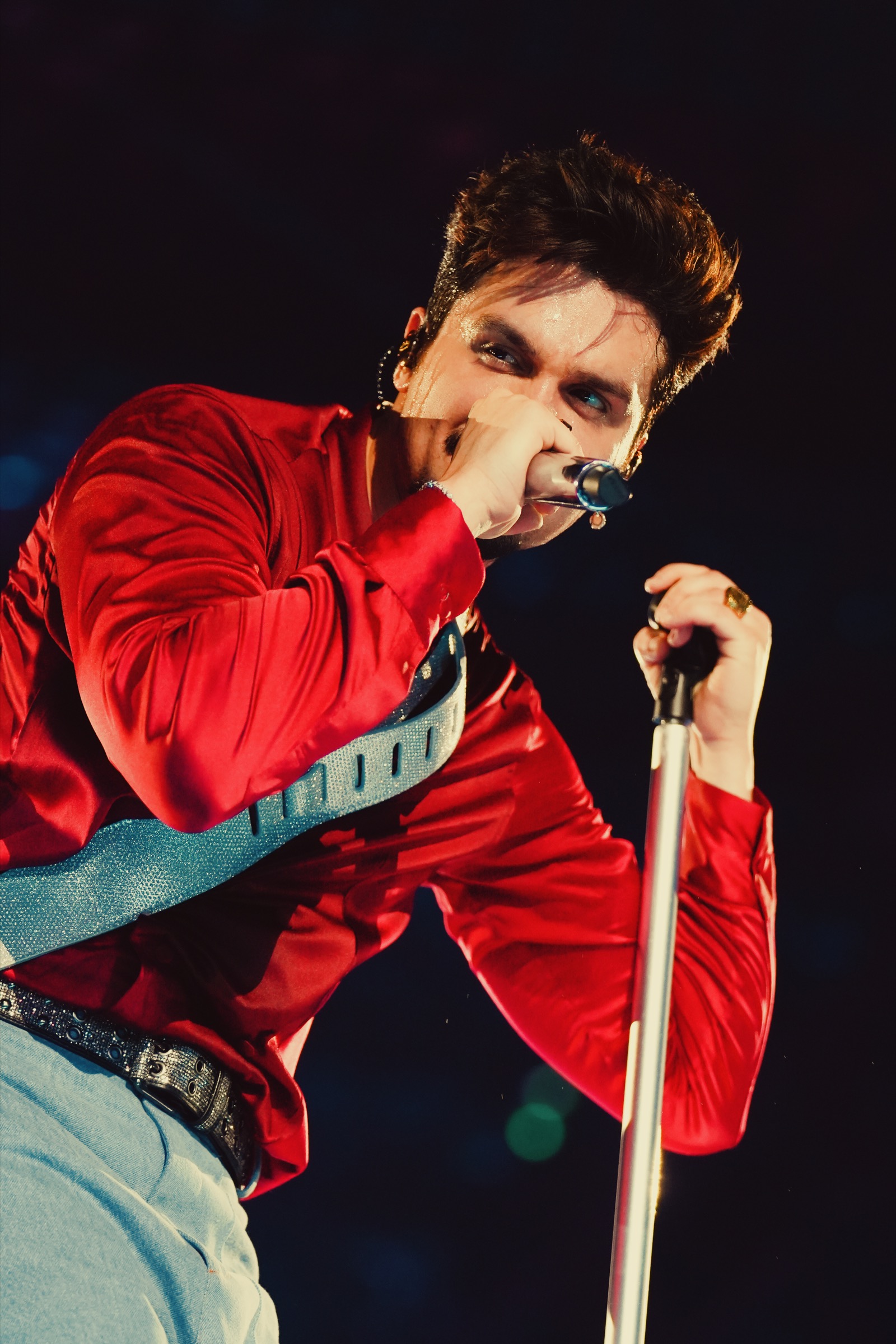 Luan Santana de camisa vermelha cantando ao microfone