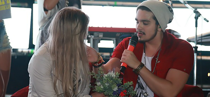 Fã ganha beijo e colo de Luan Santana durante show